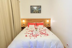 A hotel bed with red roses on it
