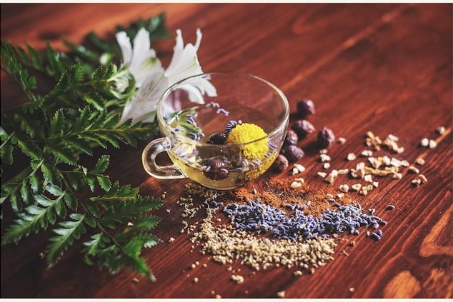 Cup of tea with herbs on a wooden surface