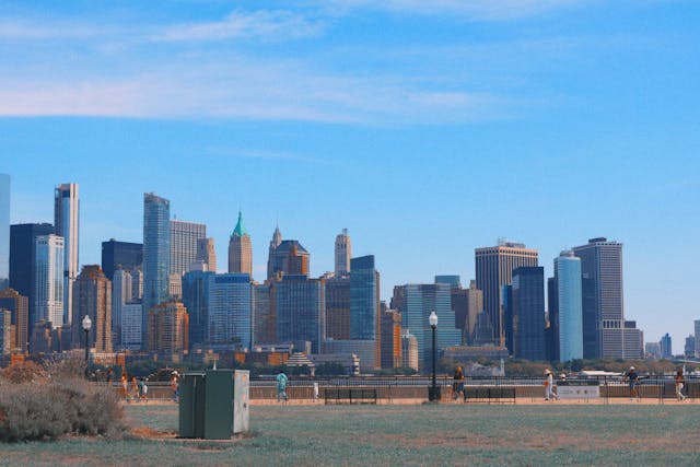 A view of Jersey City’s skyline from the waterfront, showing tall buildings against a blue sky